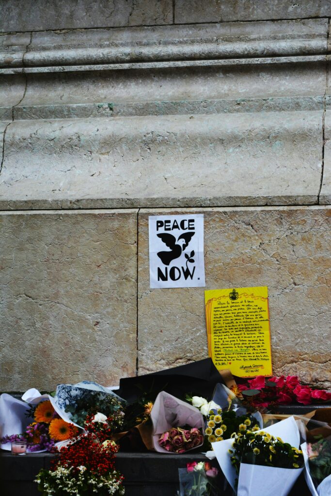 A call for peace with flowers against a historic wall, conveying a message of hope and remembrance.