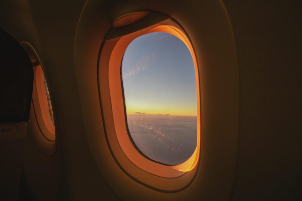 View of the sunrise from an airplane window over Bali, Indonesia. Stunning sky colors and clouds.