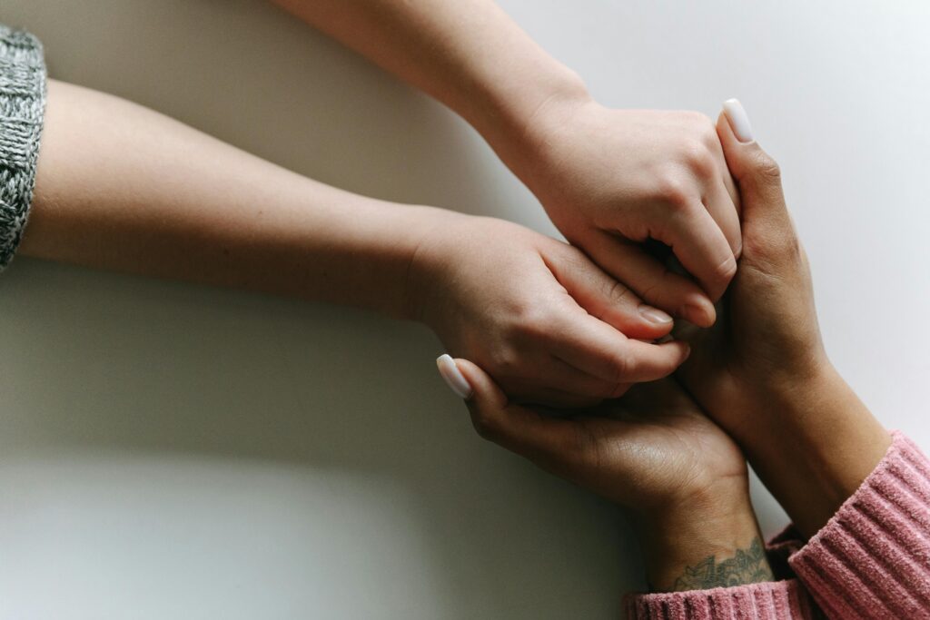 Close-up of diverse hands holding, symbolizing care, support, and friendship.